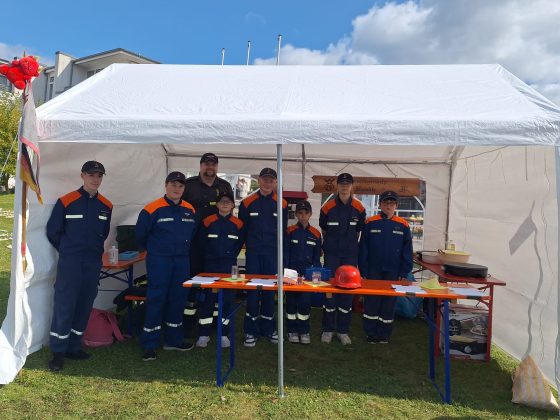 Jugendfeuerwehrgruppe in Uniformen unter Pavillon